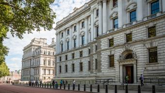 Her Majesty's Treasury Building, Government Offices in Horse Guard Road, Westminster a sunny day with white clouds and people walking