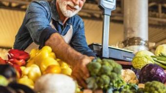 Small business owner arranging vegetables